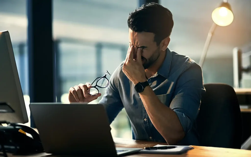 Stressed property manager at desk dealing with difficult tenants and missed rental property inspections, highlighting the need for virtual inspection solutions.